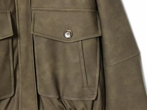 Détail de la poche cargo et du bouton en résine sur la veste en daim olive