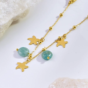 Detail of gold starfish charms and light cyan beads on a minimalist summer anklet