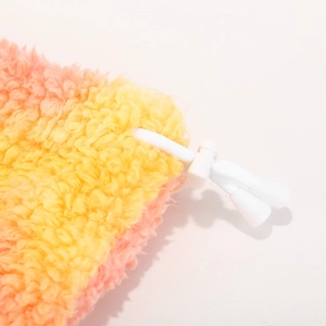Detail of tie-dye faux lamb wool fabric with adjustable white drawstring and toggle