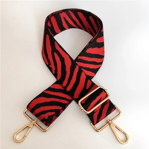 Detail of red and black zebra pattern replacement strap with gold metal hooks