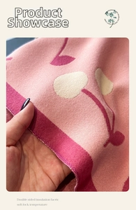 Close-up of double-sided cherry jacquard cashmere scarf showing thick knitted texture