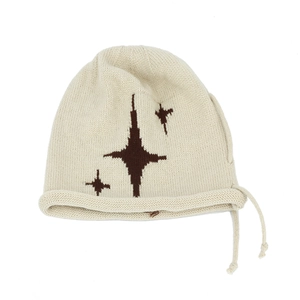 Close-up of cream knit beanie featuring brown star patterns and drawstring details