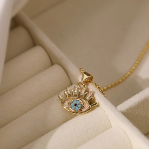 Golden 18K gold-plated Evil Eye necklace with turquoise stone in a beige jewelry box
