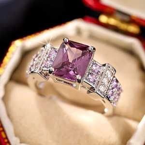 Macro shot of rectangular purple gemstone ring with ornate micro-paved silver band