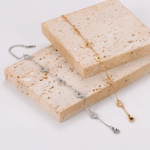 Detail of gold and silver heart-shaped bracelets with lobster clasp and extender chain