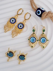 Dettaglio macro di orecchini Evil Eye placcati in oro con resina blu e zirconi incastonati