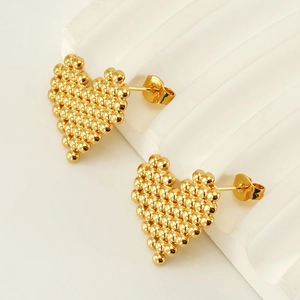 Boucles d'oreilles cœur en titane plaqué or avec petites sphères sur fond blanc
