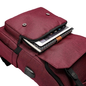 Detail view of the red Oxford cloth backpack showing the USB charging port and logo patch