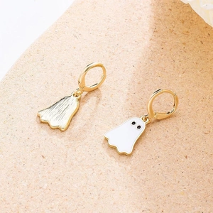 Detail of gold ghost pendant earrings with white enamel finish and textured metal back