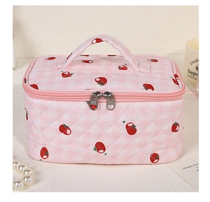 Detail of pink strawberry quilted makeup bag with double zipper and top handle