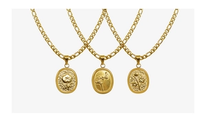 Vue détaillée de trois pendentifs ovales dorés avec relief floral et chaînes Figaro