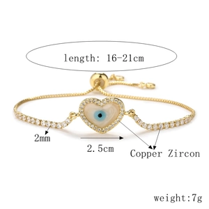 Detail of gold evil eye heart bracelet with zircon stones and adjustable chain slider
