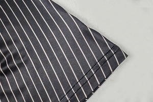Detail of vertical black and white striped fabric with double-needle stitching on the hem