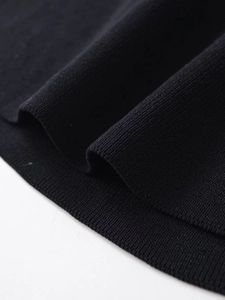Macro view of high-quality black ribbed knit fabric with delicate texture and stitching