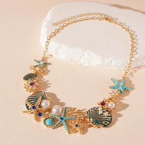 Détail du collier style marin avec étoile de mer, coquillages et perles sur fond beige