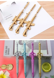 Detail view of creative weapon-shaped pens in gold and silver with metallic finish