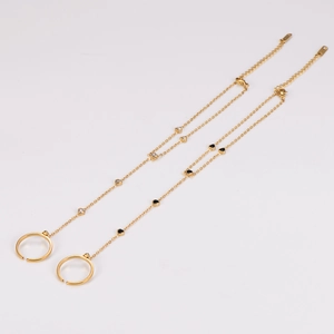 Elegant gold ring bracelet with delicate chain featuring a black heart and white crystals