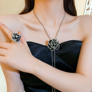 Macro view of black oil-drop rose flower necklace and ring set with crystal details