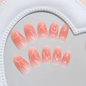 Pink blush gradient press-on nails with white hand-drawn heart lines on mirror base