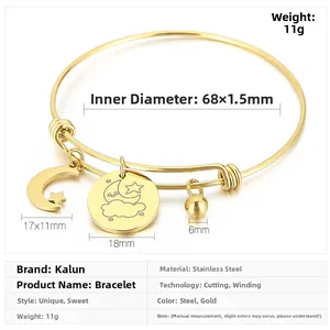 Detail view of gold adjustable stainless steel bangle with moon and star charms