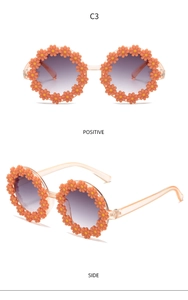 Macro detail of sunflower children sunglasses with orange petals and purple gradient lens