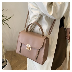Detail of pink PU leather handbag showing flip-top closure and metal twist lock detail