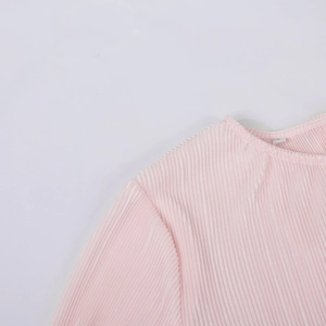 Detail of light pink pleated blouse featuring a round neck and textured vertical fabric