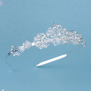 Detail view of silver alloy headband with intricate hollow flowers and sparkling rhinestones
