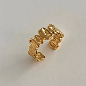 Macro shot of S925 hallmark on irregular gold-plated lava texture silver ring