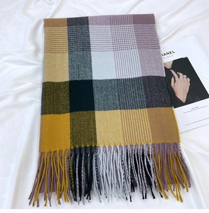 Close-up of ginger, purple, and grey checkered scarf with thick tassels and soft texture
