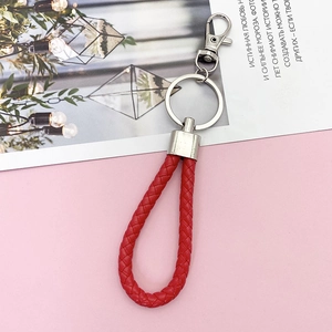 Detail of red braided leather keychain with silver alloy spring clip and key ring