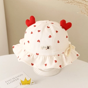 Detail of baby cotton bucket hat with heart prints, rabbit label and 3D heart ornaments