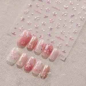 Macro shot of 3D embossed pink sakura nail art stickers with delicate gold accents