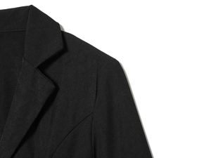 Detail shot of the notched lapel and shoulder seam of a black lace-spliced blazer