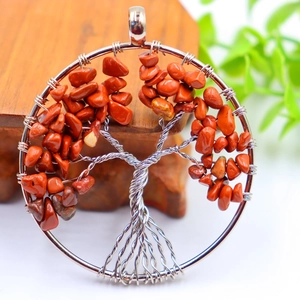 Silver tree of life pendant featuring natural red crystal stones in a round frame