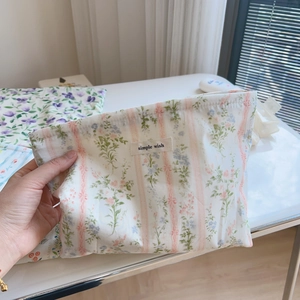 Detail of floral cotton makeup bag with zip closure and simple wish woven label