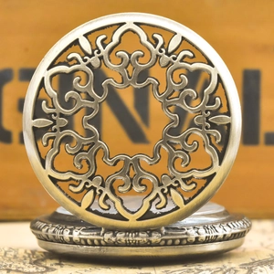 Macro detail of vintage bronze hollowed-out flower patterns on a classic pocket watch lid