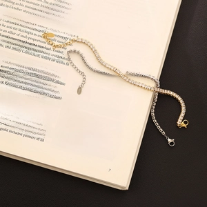 Detail of silver and gold tennis bracelets with square zircons on an open book