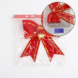 Red Christmas bow decoration with gold Merry Christmas lettering and a small bell