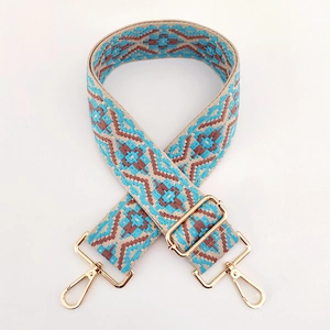Close-up of wide ethnic jacquard strap with geometric patterns and gold metal buckles