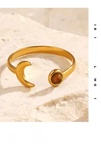 Detail of adjustable gold ring with crescent moon and round Tiger Eye stone on stone