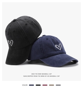 Detailed view of heart embroidery on washed cotton baseball caps in various colors