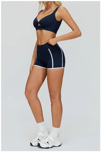 Dettaglio del reggiseno sportivo blu navy con nodo e pantaloncini con bordini bianchi