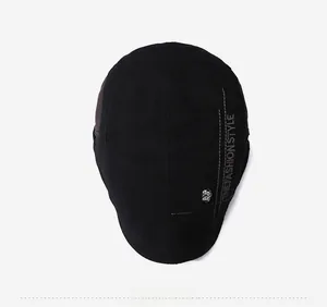 Detail view of cotton beret featuring skull emblem and sports embroidery on black canvas
