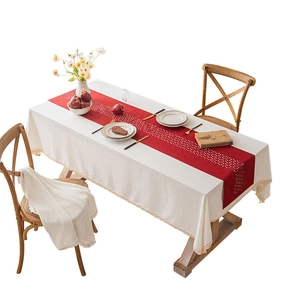 Red hollowed-out table runner on cream tablecloth with rustic American dining setting