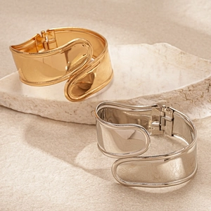 Minimalist metallic irregular cross open bangles in polished gold and silver finishes