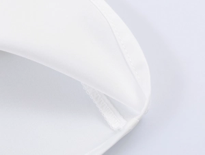 Detailed macro shot of white blouse fabric showing premium texture and professional stitching