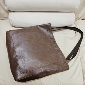 Détail du sac cabas en similicuir marron foncé avec poche externe et anses noires