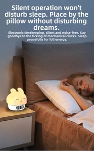 Digital rabbit alarm clock with warm night light on wooden bedside table for sleep aid