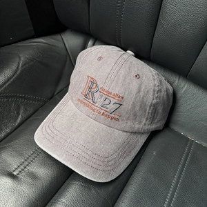 Close-up of vintage washed grey cotton baseball cap with detailed letter embroidery
